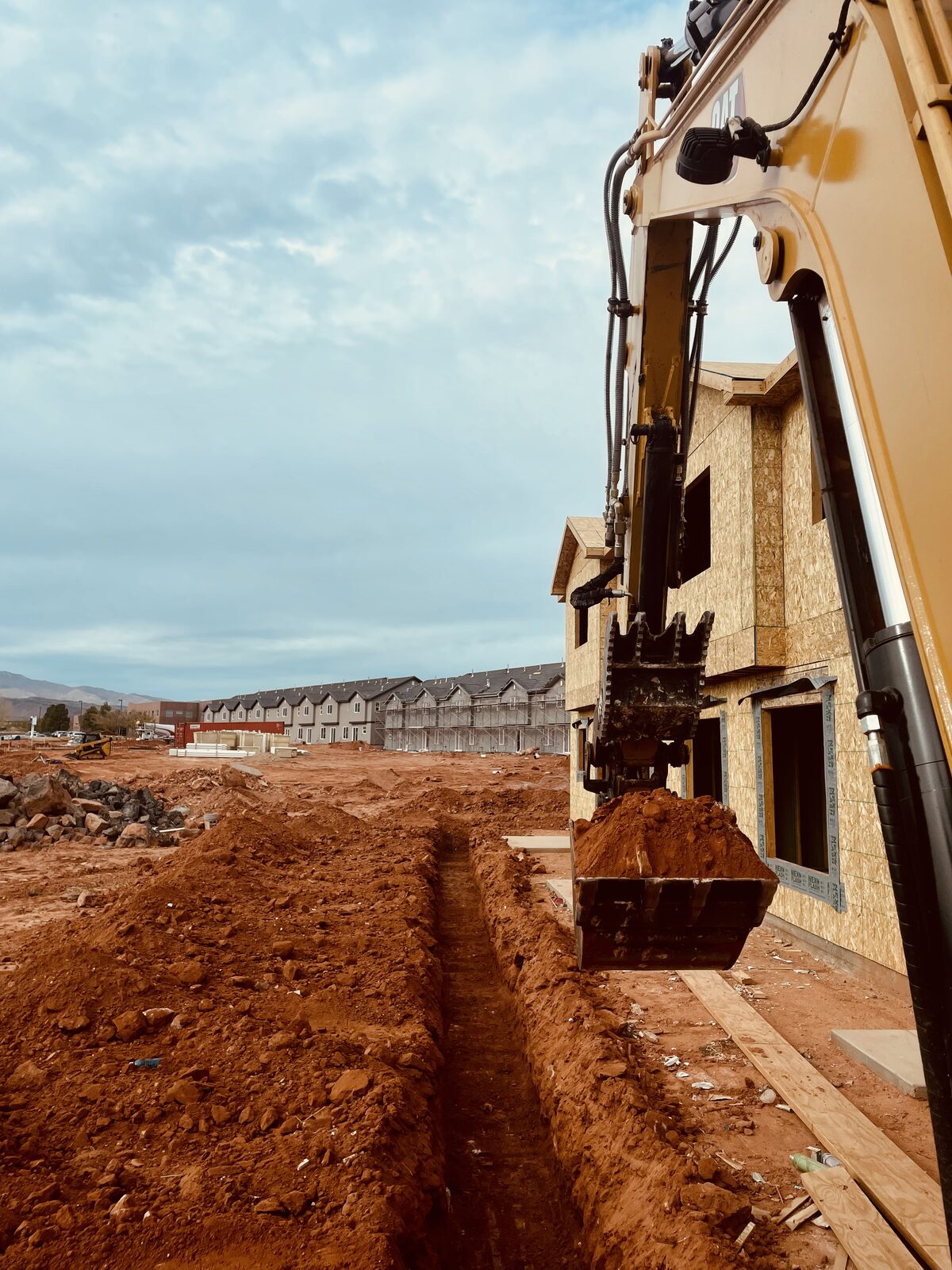 Roxor South excavator trenching utilities at a Southern Utah townhome construction project